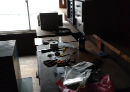片付け前の作業台に残されたドライバーやペンチなどの工具類と電子部品の仕分け前の様子｜東京都の工場片付け作業現場