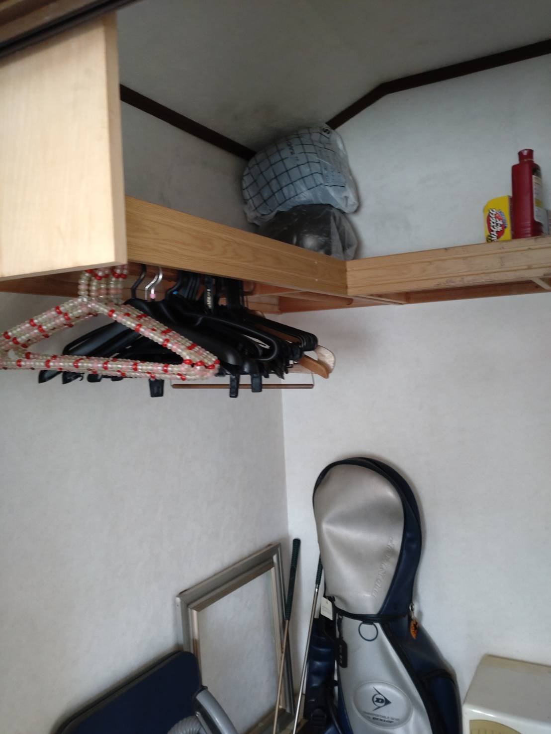 埼玉県久喜市の競売物件で上段棚収納とハンガー類が残る収納スペースの施工前状況