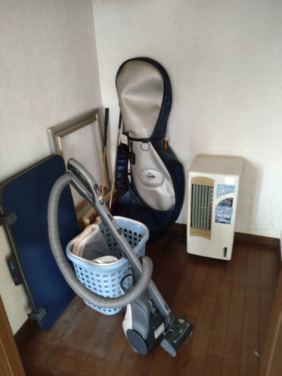 埼玉県久喜市の競売物件で掃除機やゴルフバッグなどが残る収納スペースの施工前状況